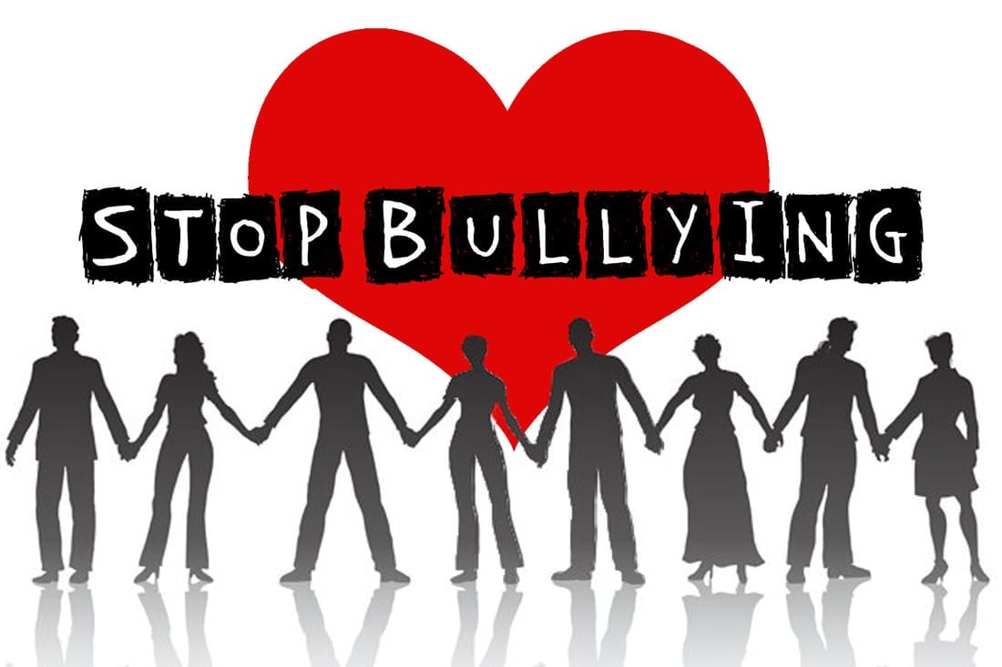 A group of people holding hands in front of a heart with the words stop bullying.